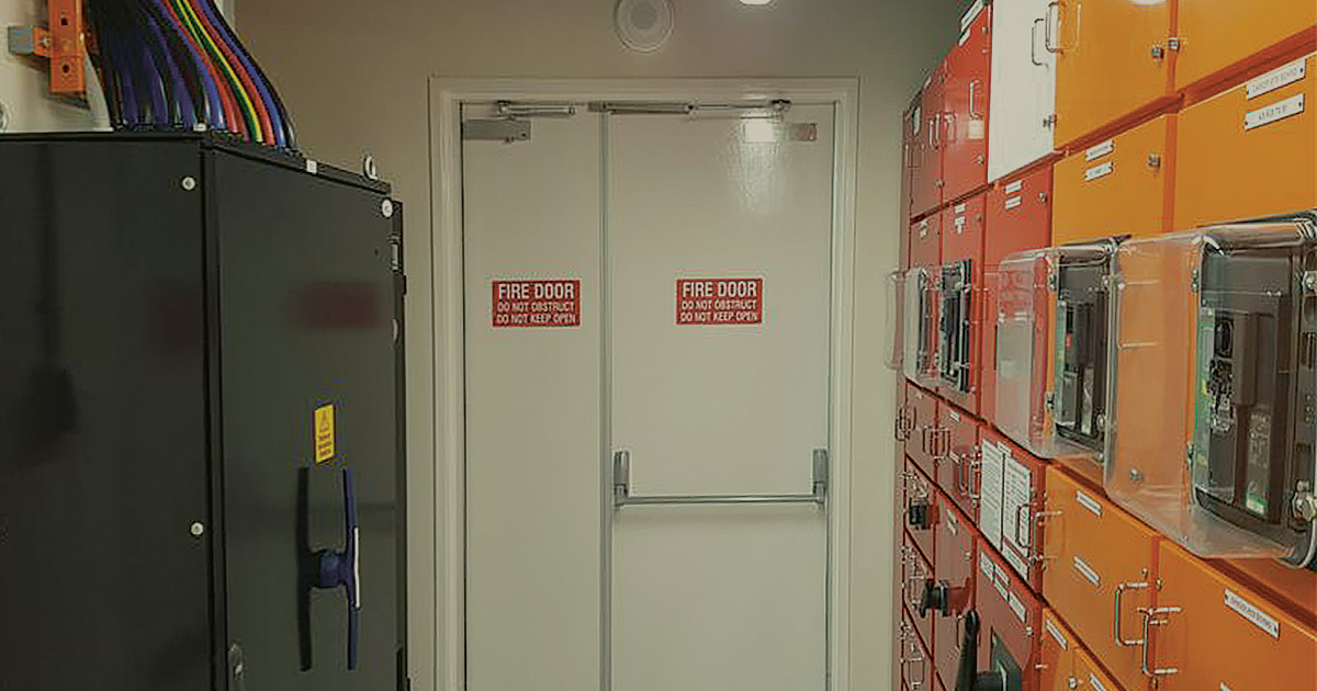 Orange and white lockers in an organised hallway at Pier St POD supporting Critical Power Systems and Critical HVAC Systems