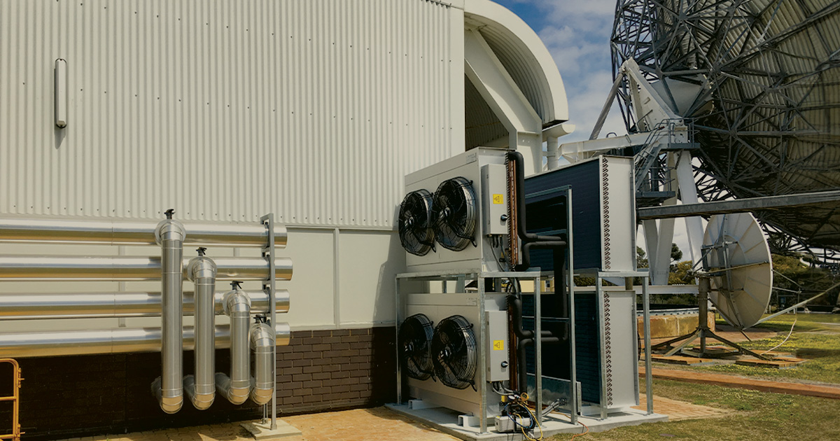 Large white PITC building with rooftop antenna supporting data centre cooling infrastructure