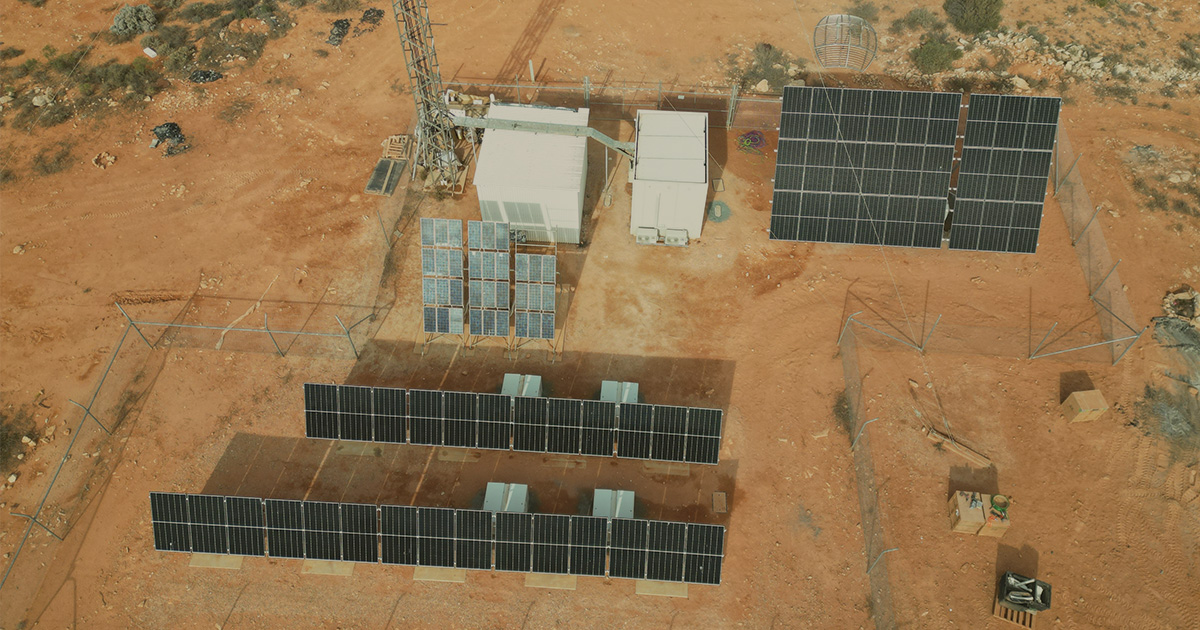 Aerial view of solar panels in a desert powering an off grid solar hybrid system for Australian rail telecommunications.