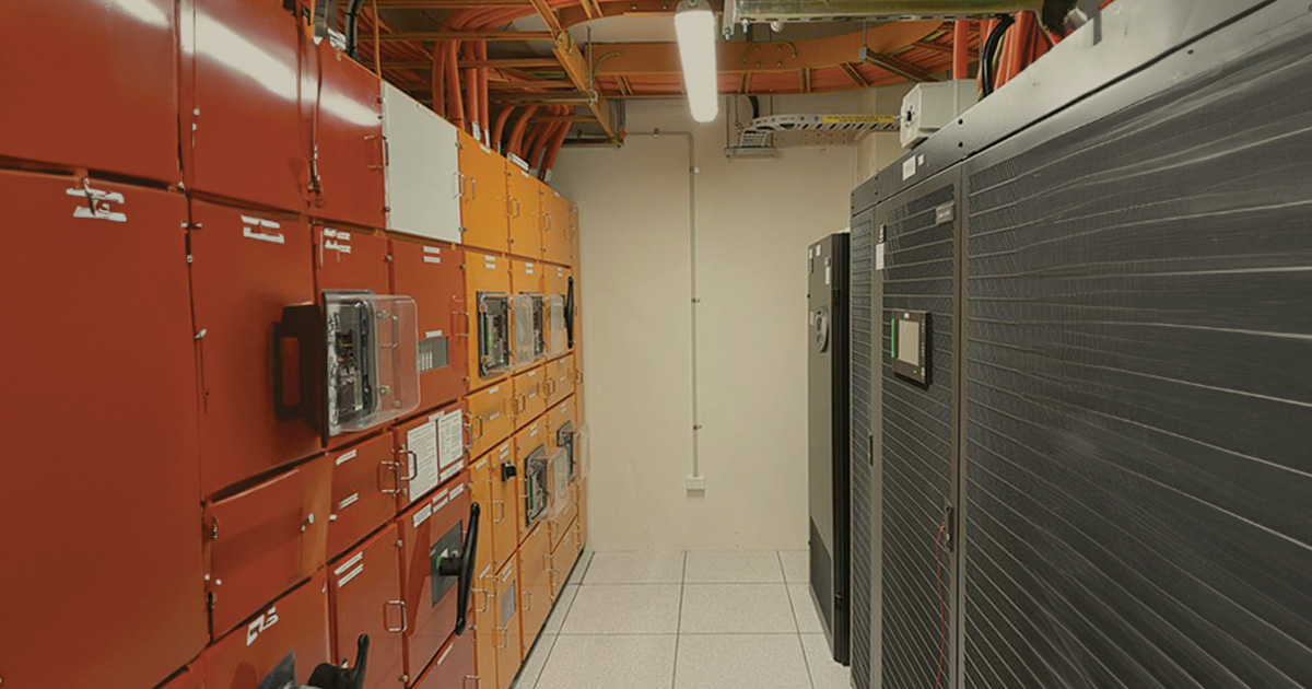 Red and orange storage cabinets along a hallway at Pier St POD supporting Critical Power Systems and Critical HVAC Systems