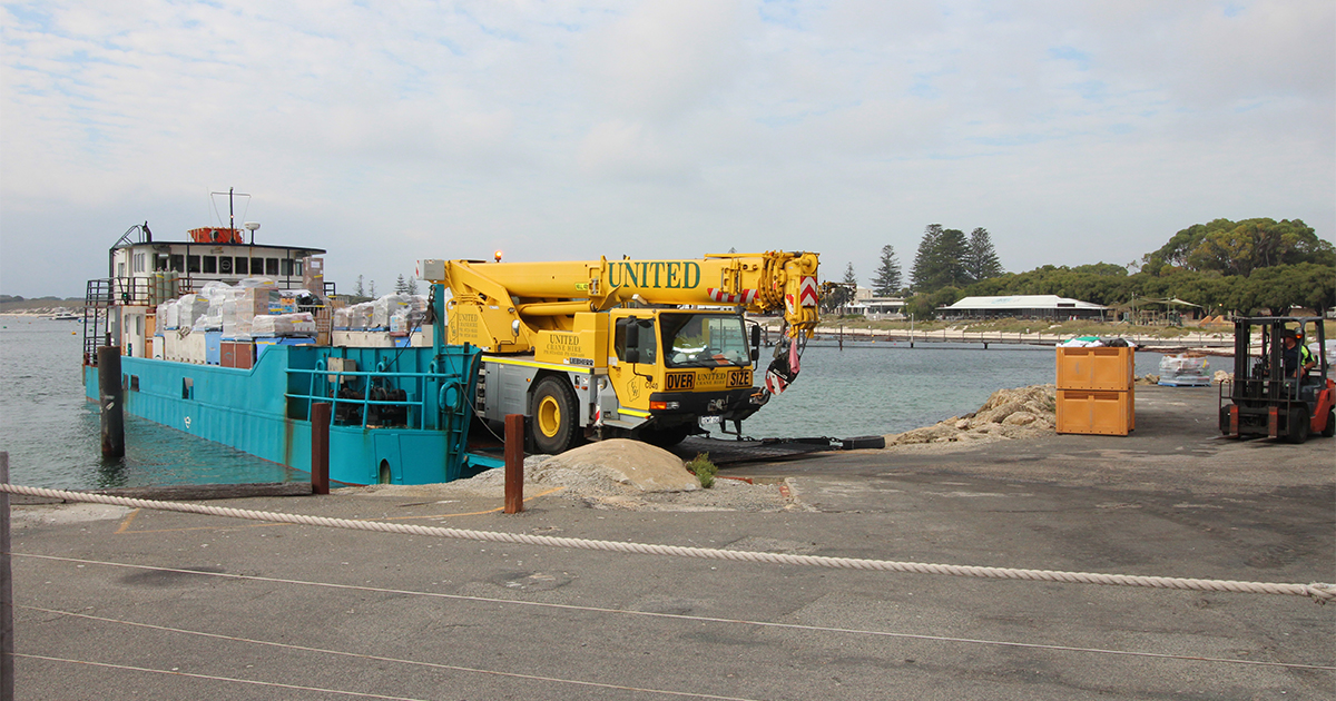 Yellow Hiab crane truck beside a boat supporting DCE Freight & Logistics services at Rotten Island for backup power systems .