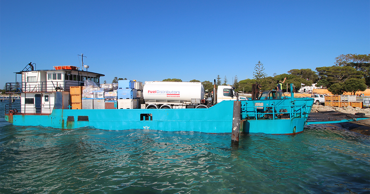 Blue cargo ship anchored in calm waters for remote area logistics supporting backup power systems installation.