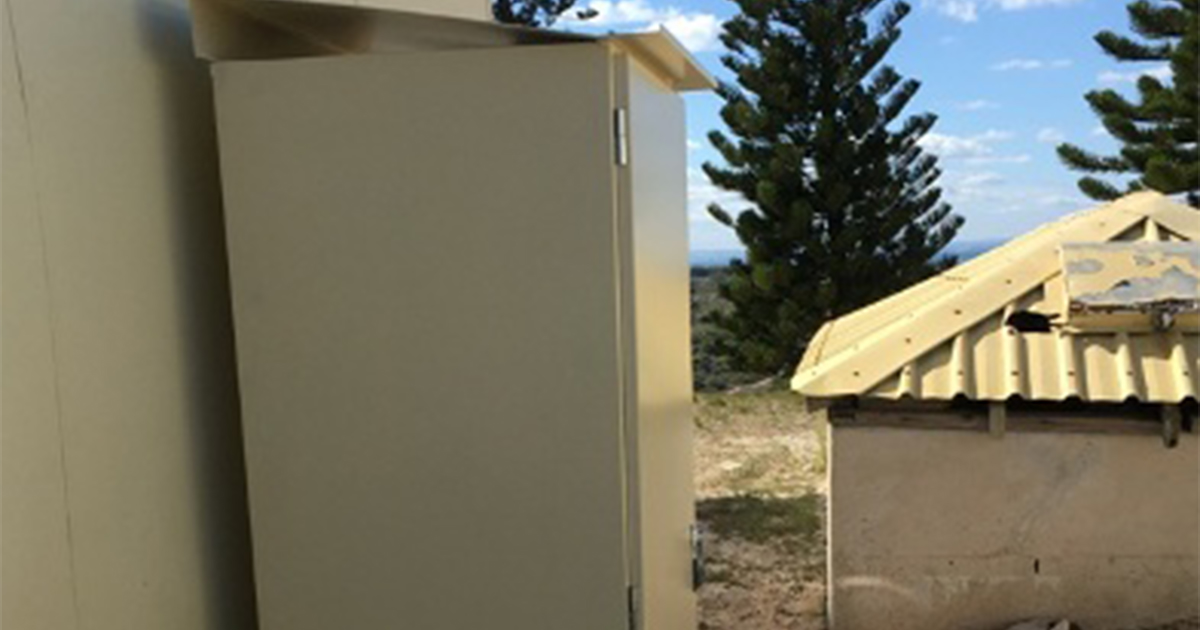 White electrical cabinet beside an aircon unit supporting backup power systems installation at Rottnest Island.